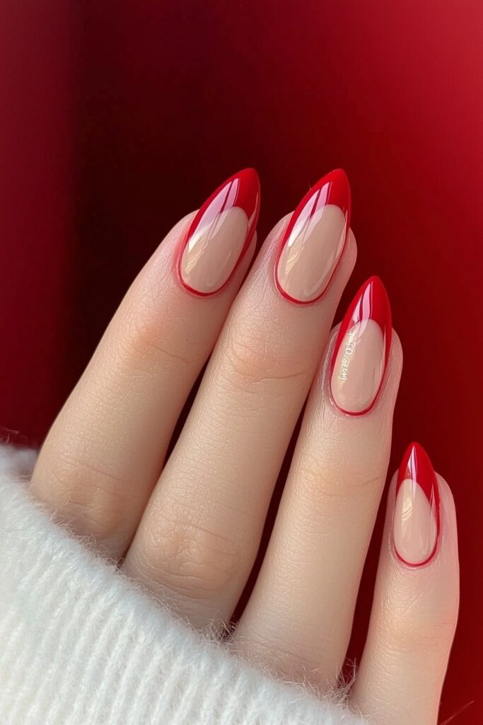 Pink nails with red French tips against red background, Christmas-inspired