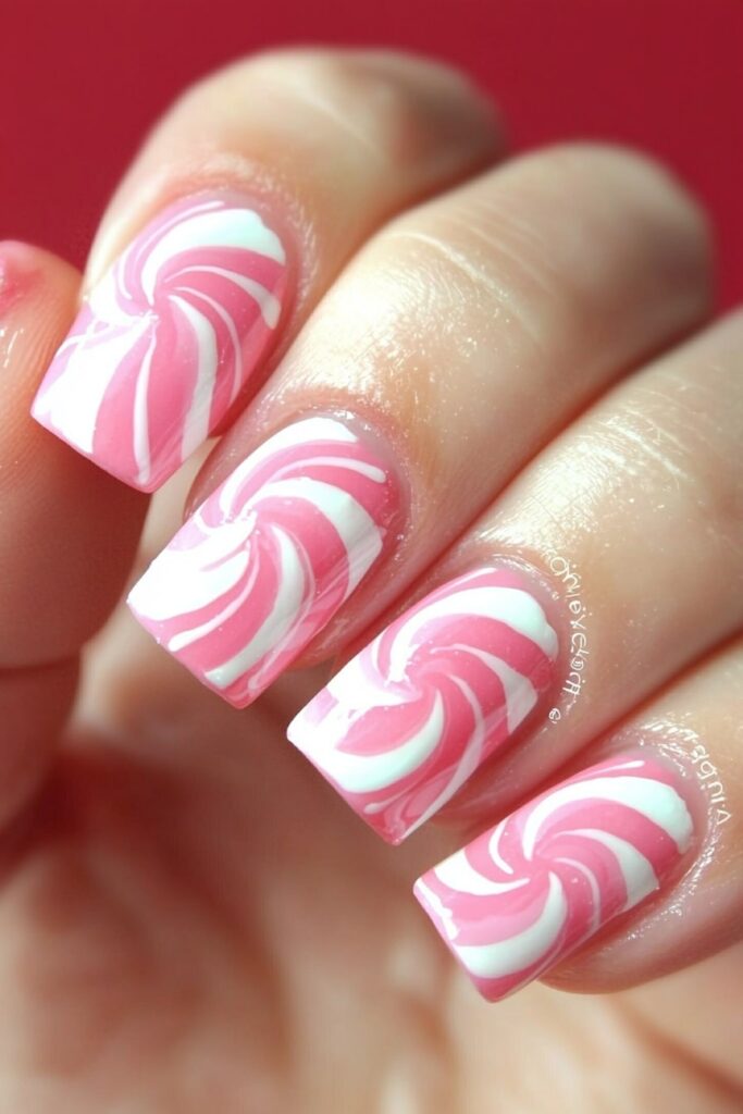 Pink and white swirled peppermint Christmas nail art design