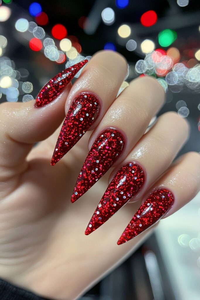 Christmas red acrylic stiletto nails covered in sparkly glitter