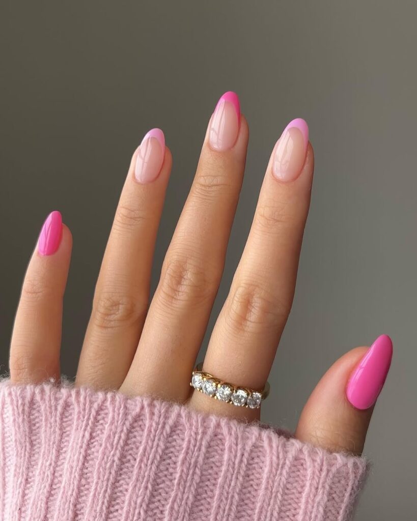 Almond-shaped nails with vibrant Barbie pink French tips and a glossy finish for a playful yet elegant summer look.