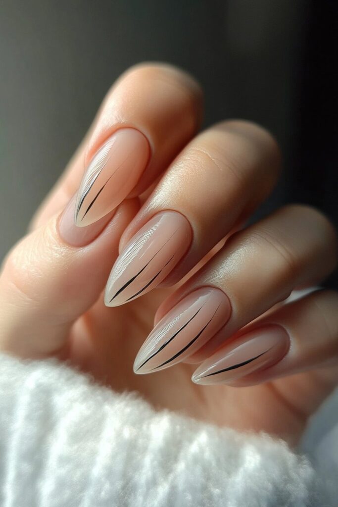 Modern almond-shaped nails with minimal striping, showcasing thin lines in contrasting colors for a sleek, stylish look