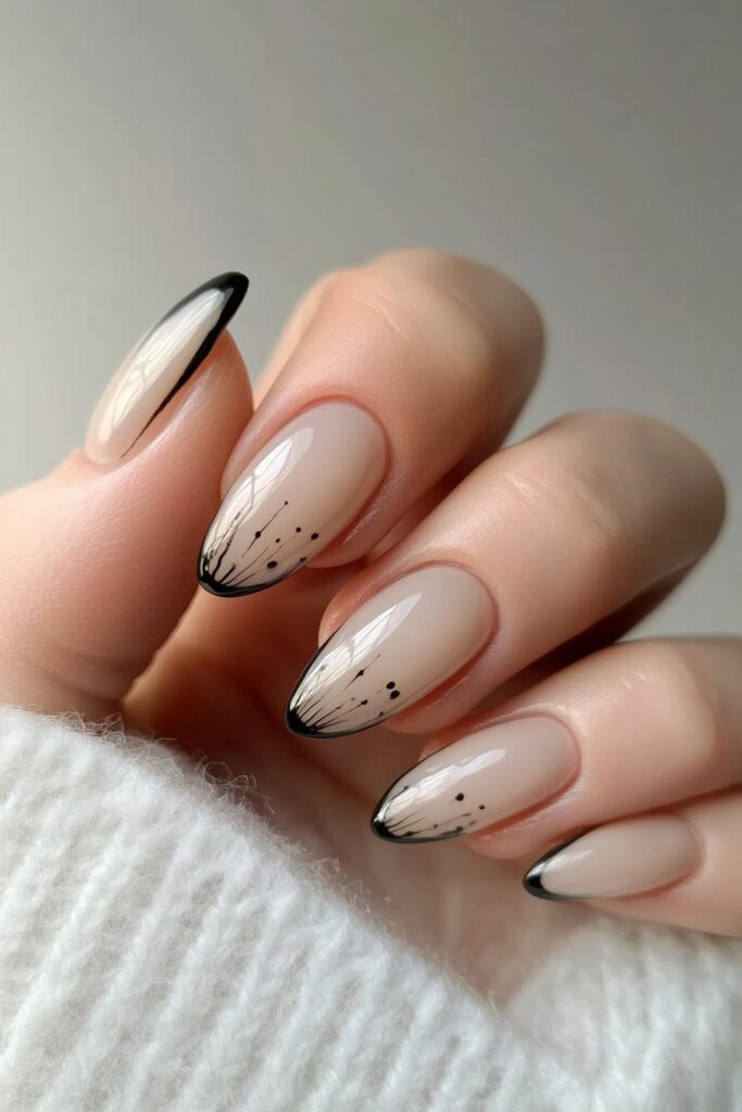 Almond-shaped nails with a nude base, decorated with elegant black minimalist line art in abstract and organic shapes.