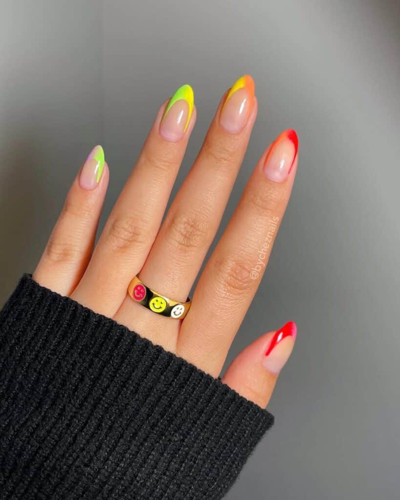 A colorful summer nail design featuring rainbow French tips on acrylic nails. Each nail displays a different bright hue, creating a playful gradient effect.