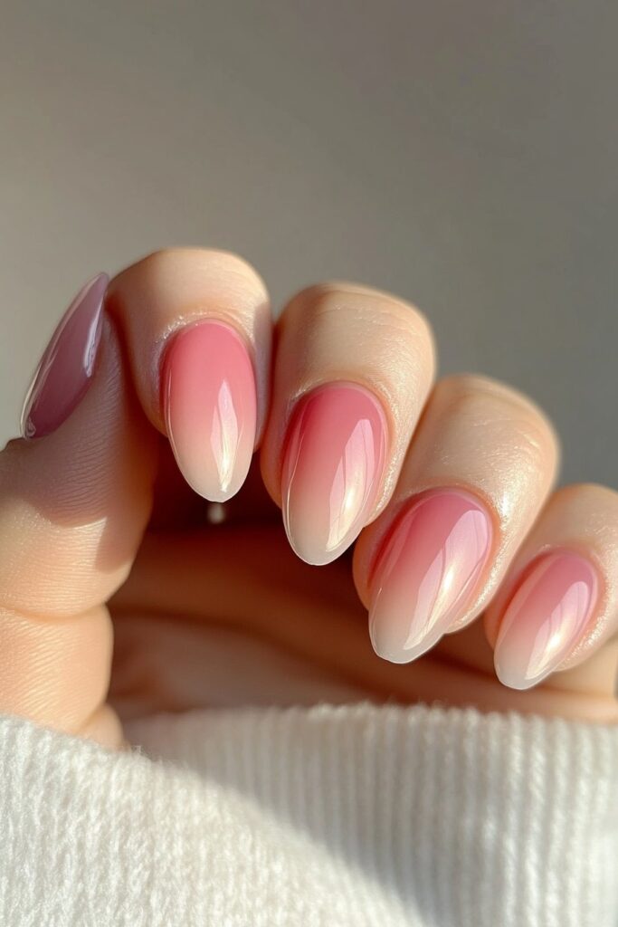 Almond-shaped nails with a sunset gradient blending warm orange, pink, and purple hues, mimicking a tropical summer evening sky.