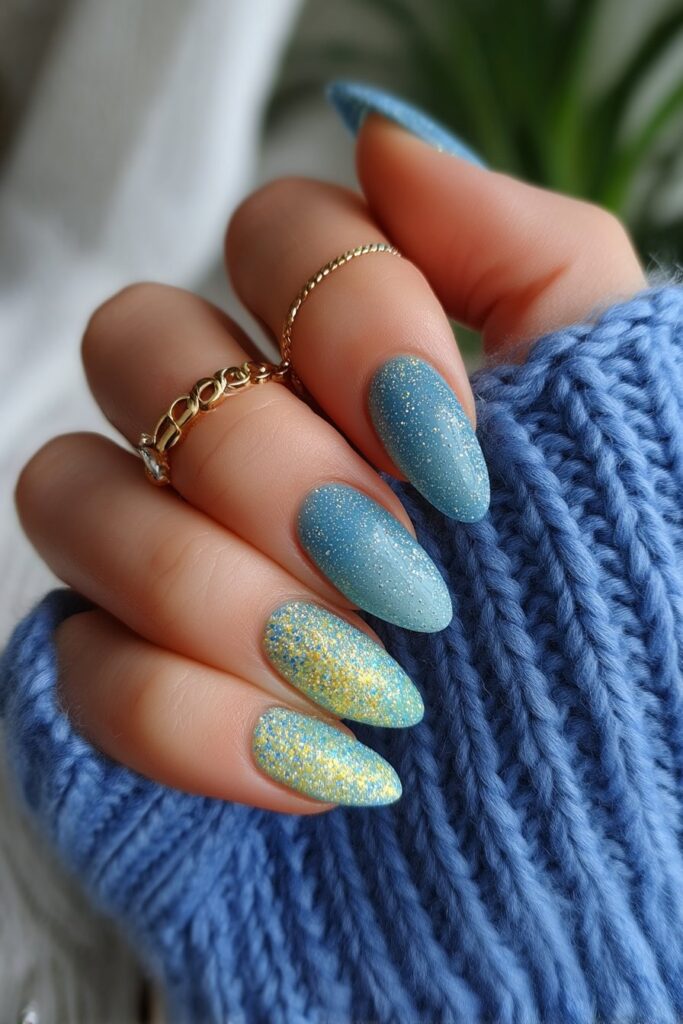 Iridescent almond-shaped acrylic nails with glittery teal bases and shimmery accents, inspired by mermaids to create a magical underwater fantasy look.