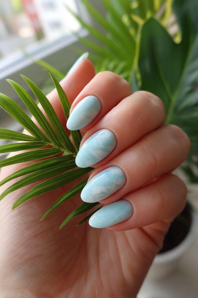 Soft pastel teal and crisp white swirls creating a dreamy, airy summer vibe across each nail, finished with a light, playful gloss.