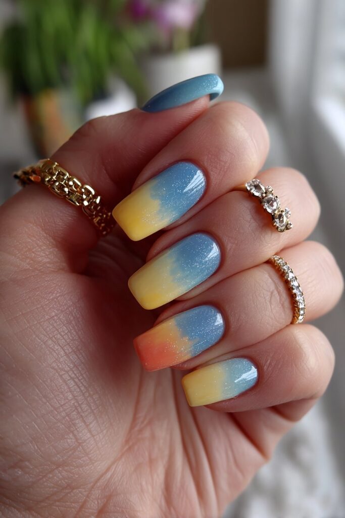 Summer nails featuring a stunning gradient from teal to coral, blending cool teal with warm sunset colors on each nail with a smooth, glossy acrylic finish.