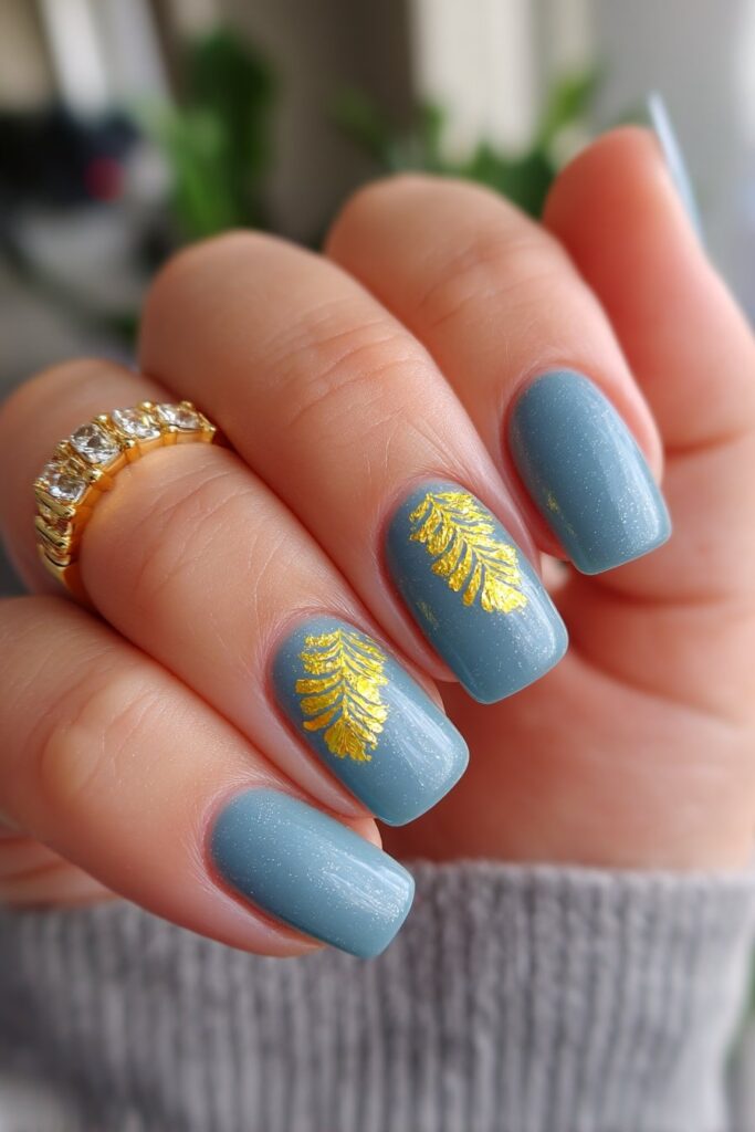 Elegant summer nails with rich teal backgrounds and luxurious gold foil accents on each nail, creating a regal, shimmering appearance with glossy topcoat.