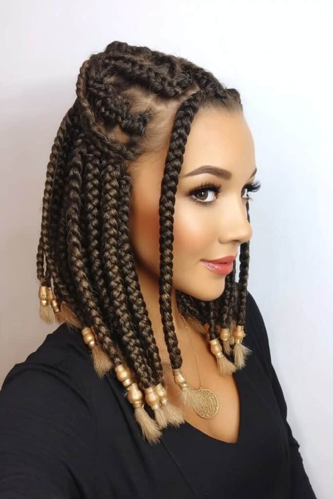 Woman with shoulder-length bob haircut featuring loose braids woven throughout, creating a textured, casual yet elegant hairstyle with natural movement.