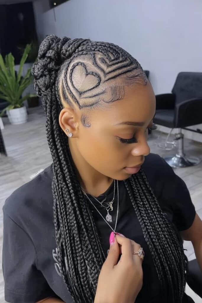 Intricate cornrow braids formed into heart-shaped pattern around head perimeter, creating romantic crown-like geometric hair design.