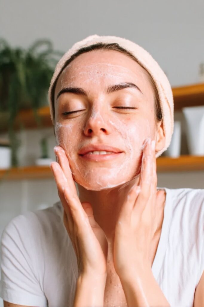 woman using face cleanser