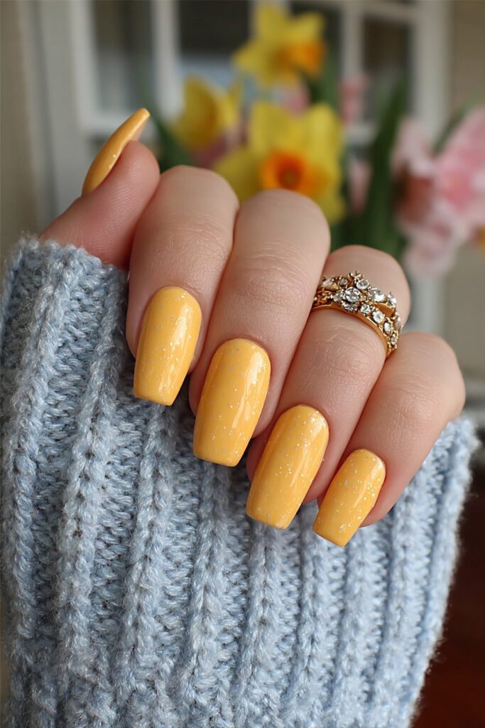 Bold coffin-shaped nails in smooth mango orange finish creating bright and tropical eye-catching summer manicure look.