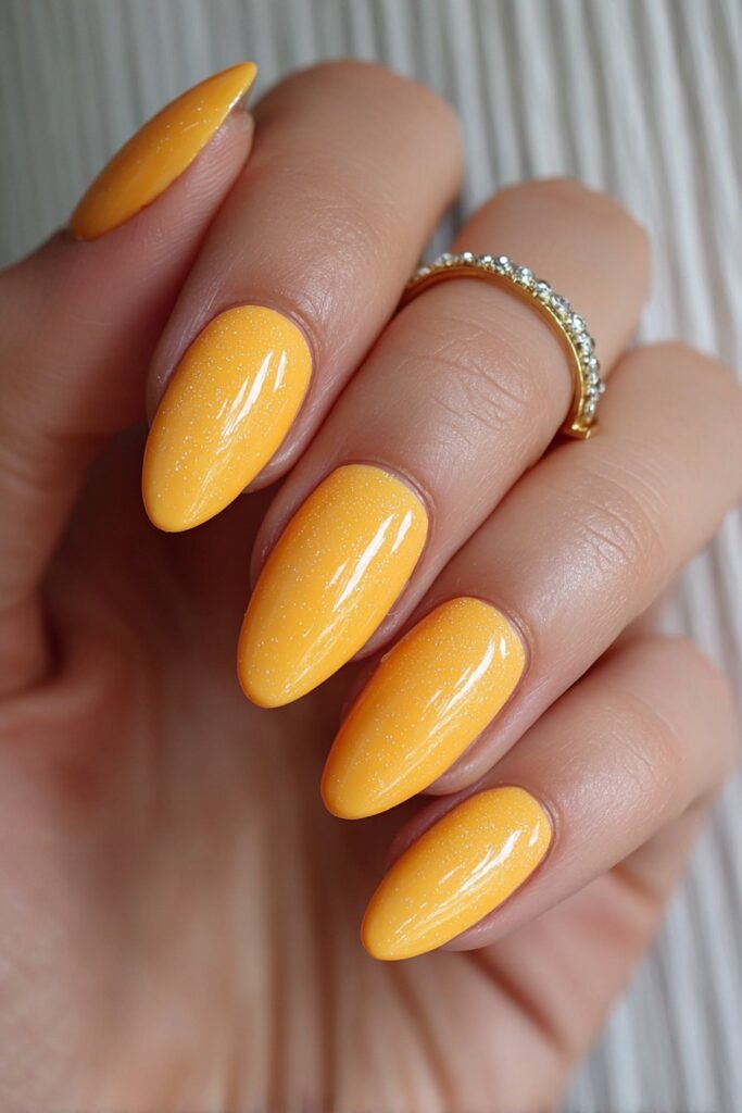 Neon orange almond-shaped summer nails with high-gloss finish creating bold and electrifying vibrant statement manicure design.