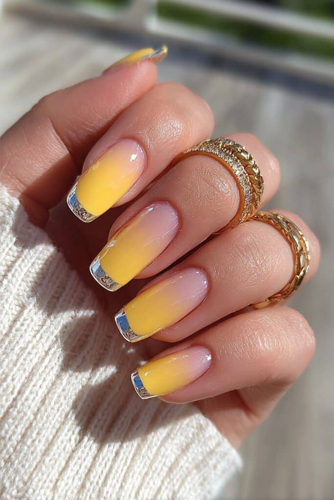 Futuristic orange French tips with reflective chrome finish creating high-shine metallic summer-inspired nail art with modern twist.