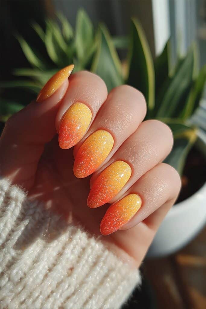 Almond nails showcasing glowing orange and red aura effect radiating bold summer energy and warmth manicure design.