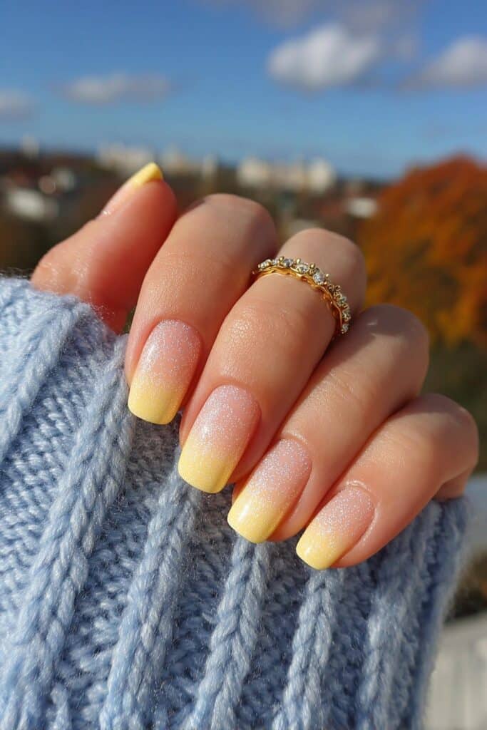 Orange French tips with glowing sunset-inspired aura fade effect transitioning into nail bed for dramatic summer nail design.