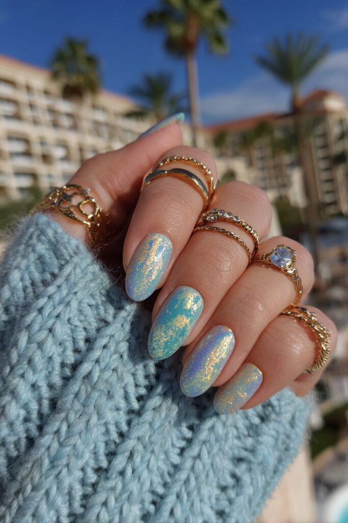 Dual-tone chrome nails in teal and lilac shades with a futuristic mirror finish.