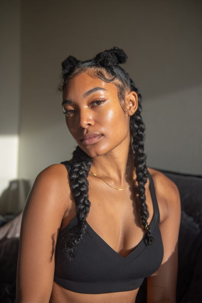 Black model featuring a mix of Fulani cornrows and bantu knots at the back, decorated with beads and cuffs.