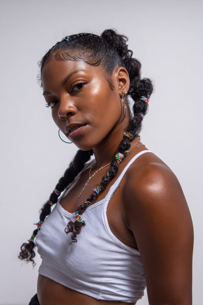 Close-up of Jayda Wayda-inspired Fulani braids with colorful beads at the tips, styled with a middle part and sleek edges.
