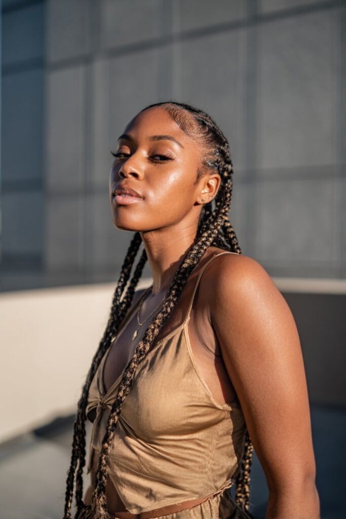 Model with Fulani braids in front and voluminous quick weave extensions in the back, styled for added fullness and length.