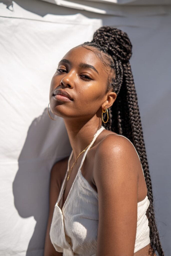 African-American model with thick jumbo knotless Jayda Wayda braids, natural shine and laid edges.