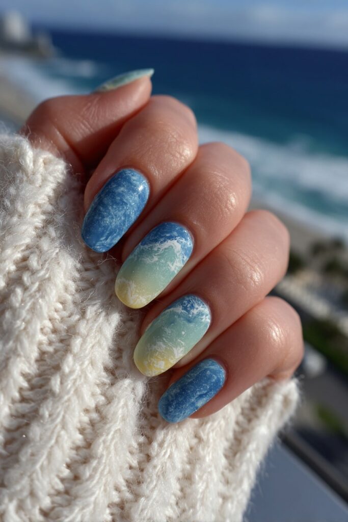 Ocean wave-inspired nails in seafoam green and ocean blue swirls with glossy water-like finish.