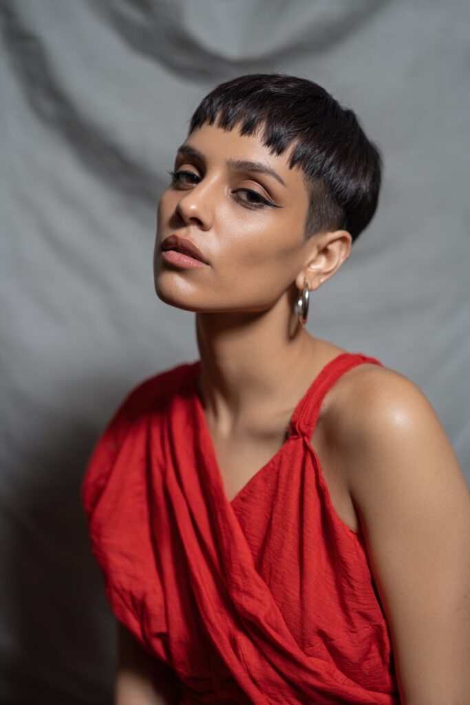 Fierce Black model with a Jayda Wayda-inspired pixie cut, featuring ultra-short micro bangs and a sleek finish.