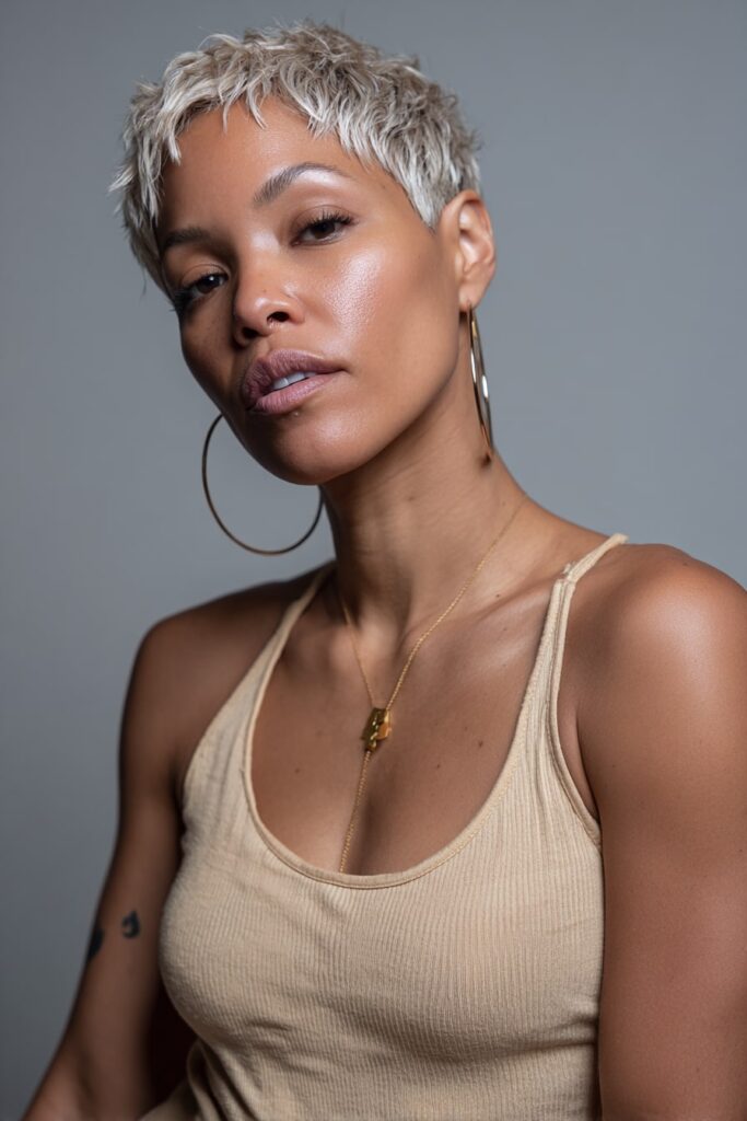 A Black woman with a soft, layered pixie cut featuring face-framing angles and subtle fringe, glowing skin and a warm expression.