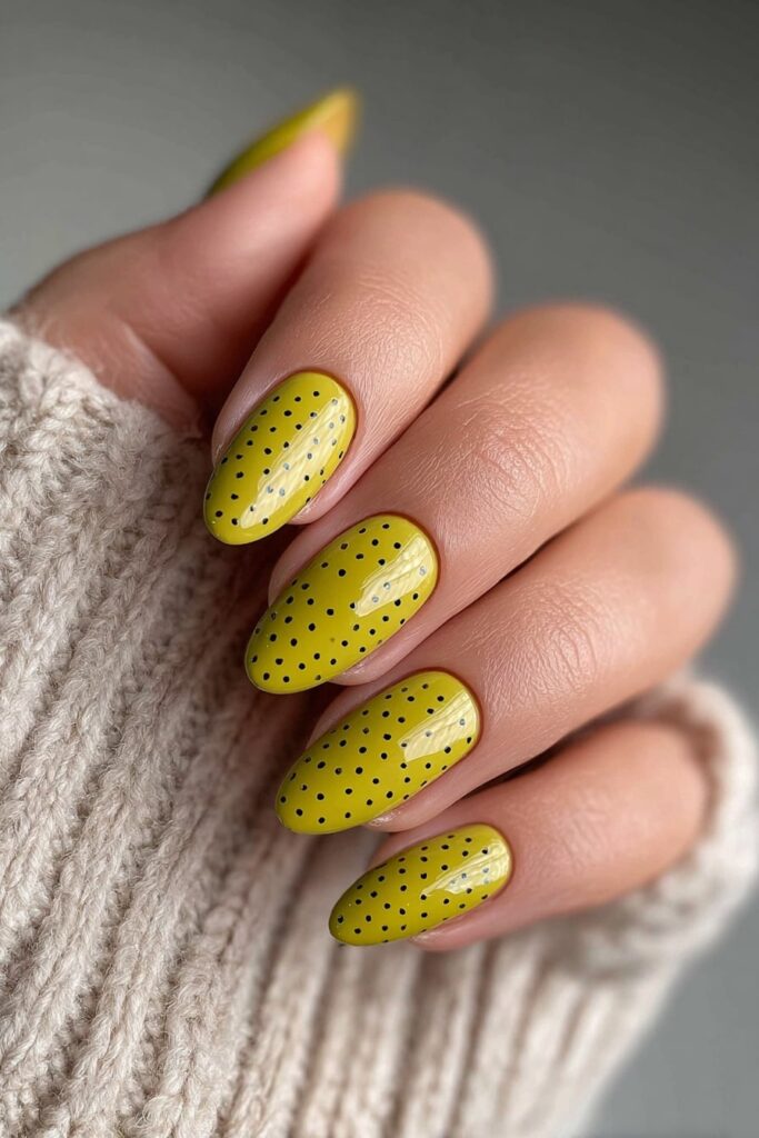 Trendy olive green nails with neat black polka dots for an earthy summer look.