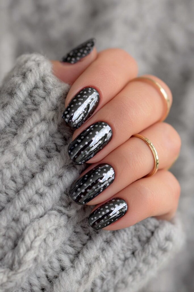 Futuristic chrome nails decorated with sleek black polka dots and metallic shine.