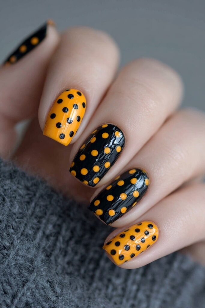 Halloween polka dot nails with classic black and orange dots for spooky festive style.