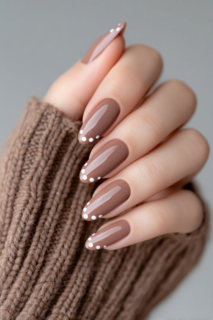 Refined cocoa brown French manicure highlighted with tiny beige dots, almond-shaped nails in glossy finish, chic neutral aesthetic perfect for everyday wear.