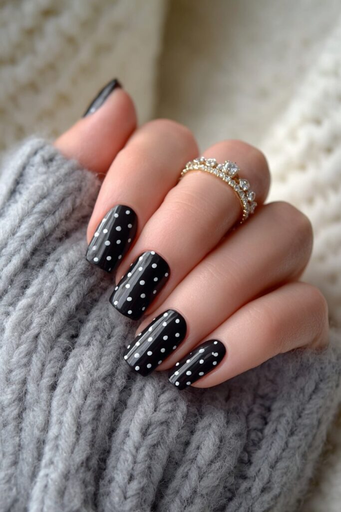 Halloween ghost nails with white polka dots on matte black background for spooky chic.