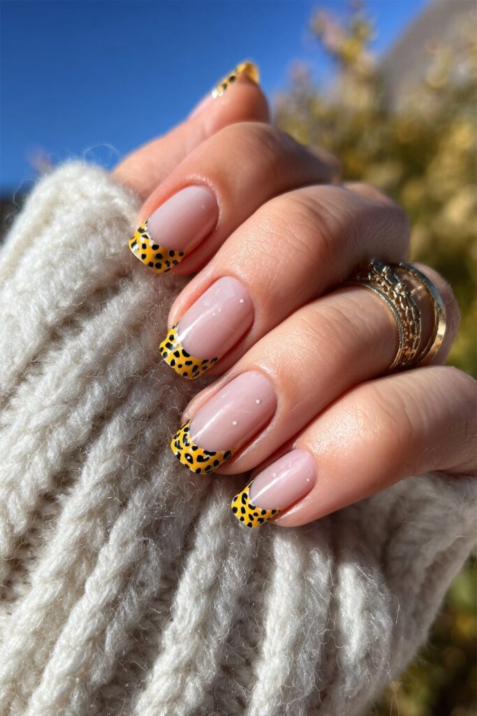Halloween French tip nails with orange and black polka dots for festive October manicure.