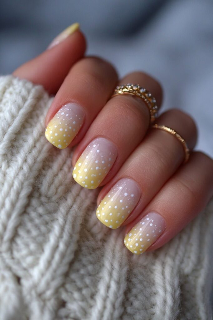 Yellow nails with a soft French fade and subtle white polka dot detailing for elegance.