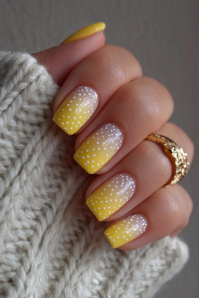 Yellow ombre nails accented with white polka dots for a bright, sunny gradient look.