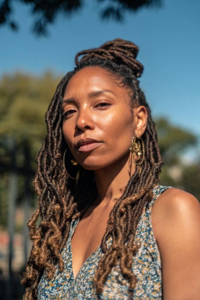 black woman with half up half down retwisted loc hairstyle