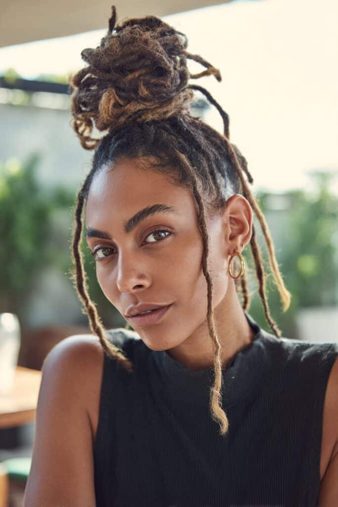 woman with messy top knot loc hairstyle