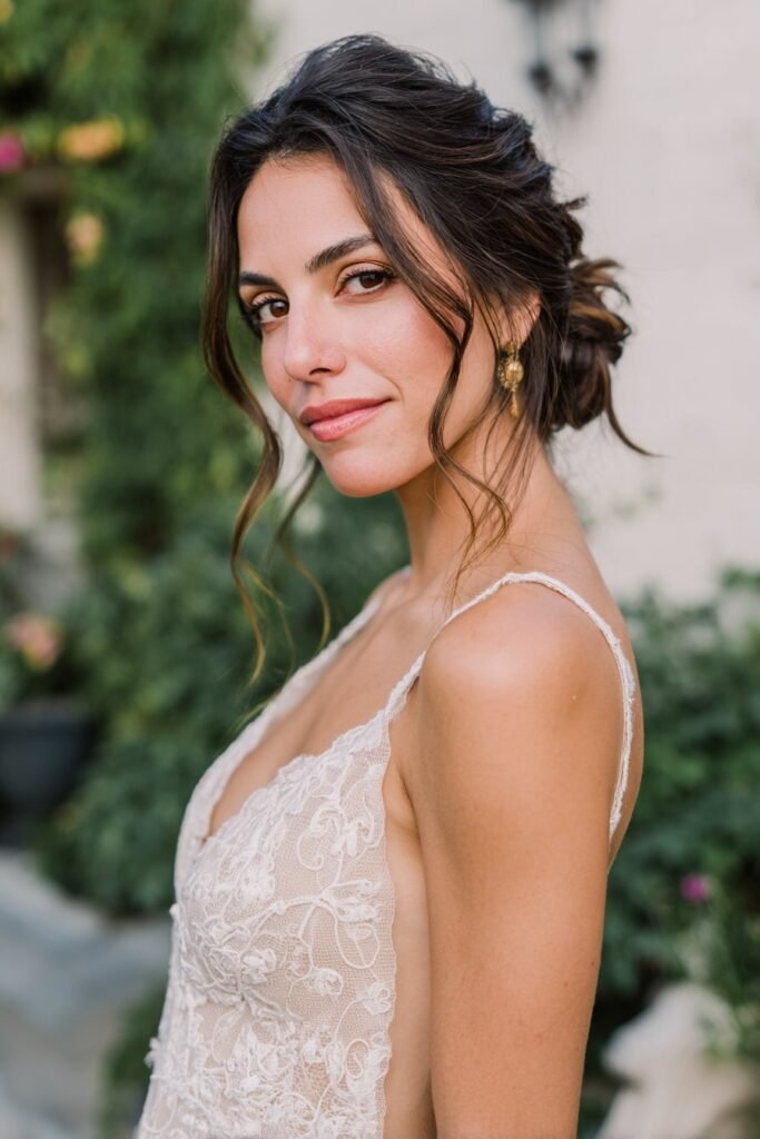 Romantic low bun with side part hairstyle for long hair and soft tendrils