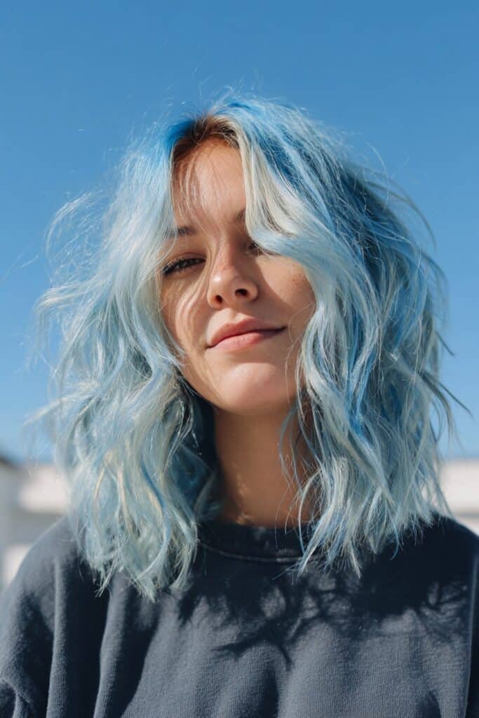curly hairstyle with soft sky blue peekaboo highlights hidden beneath