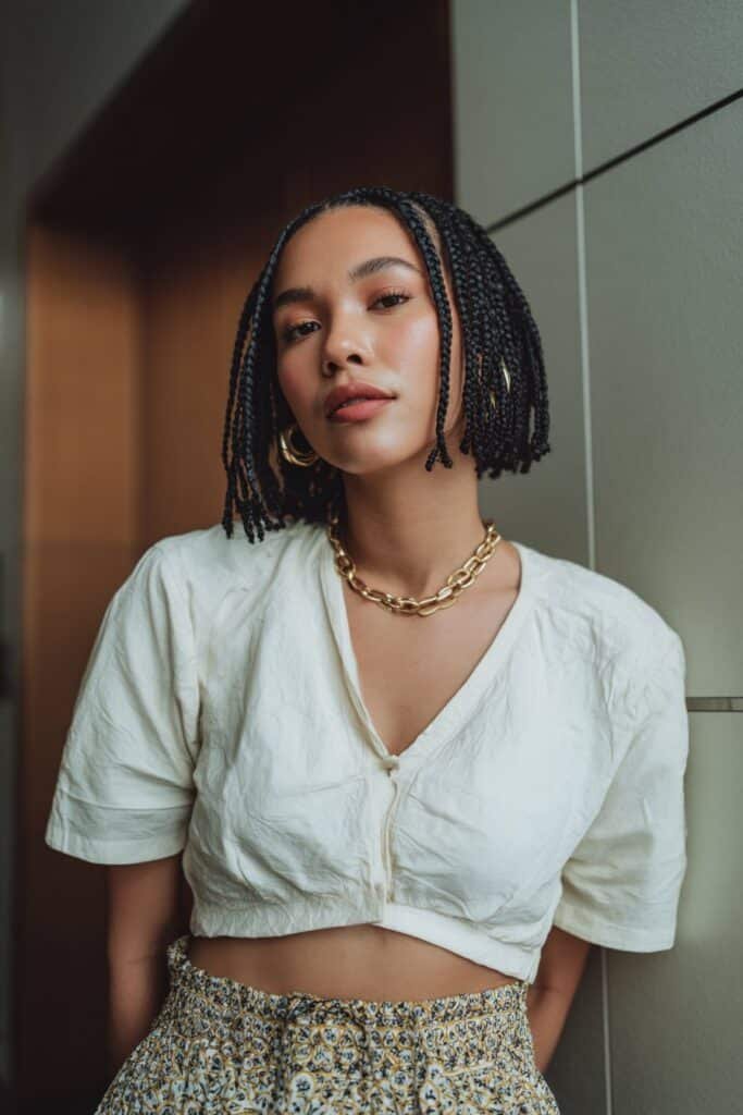Woman wearing bob-length cassie braids in a chic short style.
