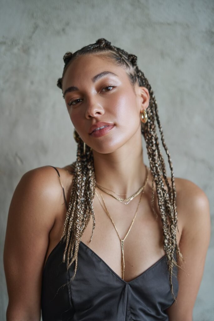Woman with cassie braids featuring soft color highlights.