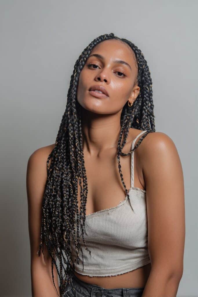 Woman with classic cassie box braids in a clean middle part.