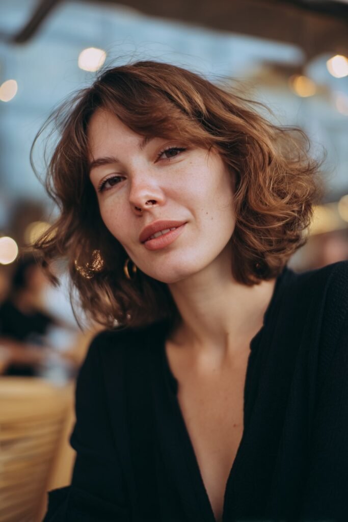 Woman wearing a classic stacked bob with loose curled layers.