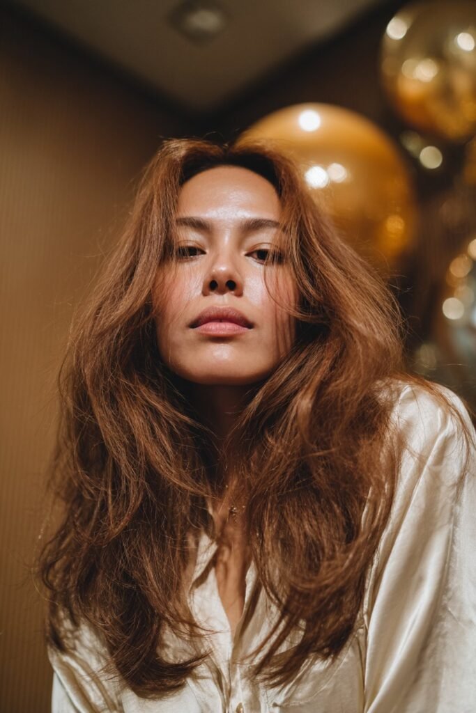 Long feathered layers with center part and airy 70s volume.