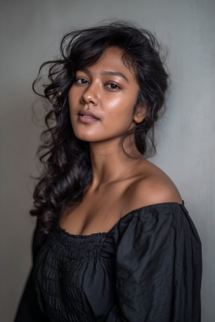 Woman with side-swept curls and voluminous medium length hair.