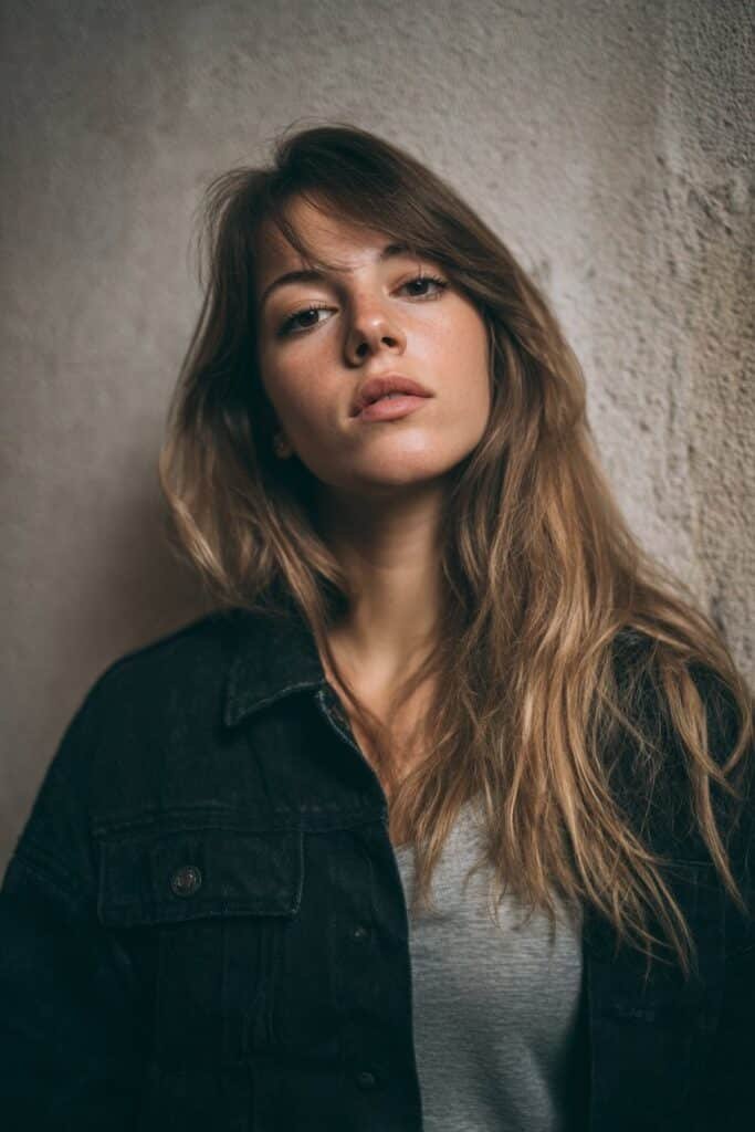 Woman with textured piecey fringe and side-part curtain bangs styled to one side.
