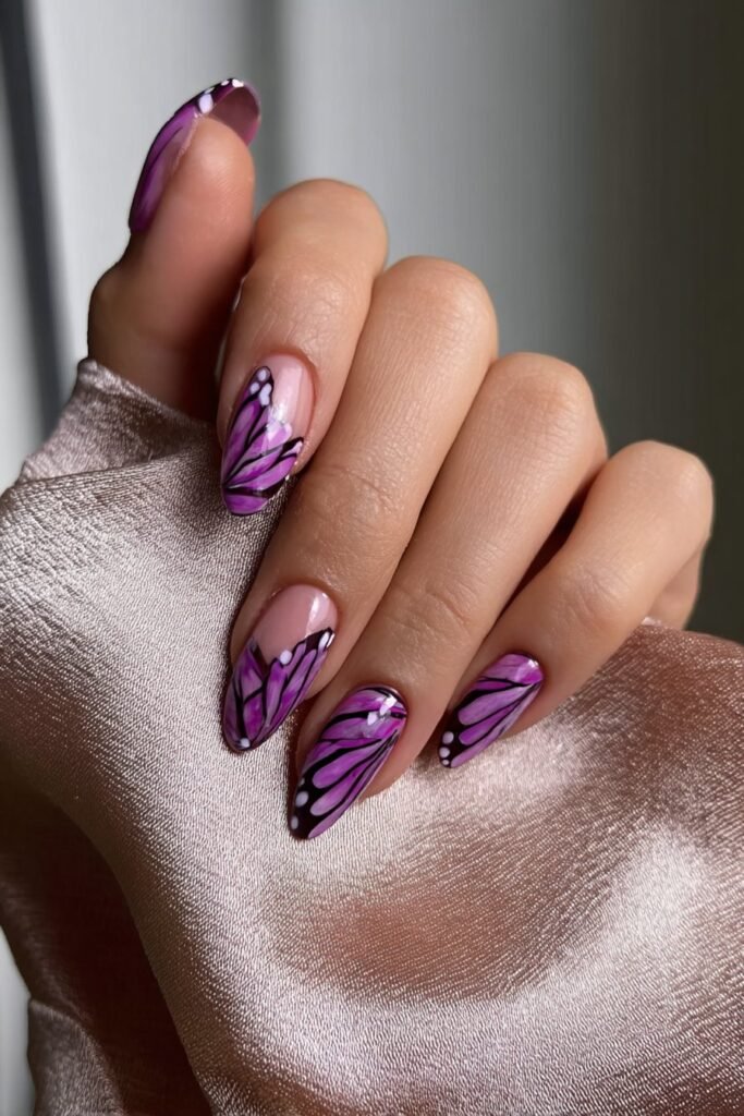Amethyst butterfly wing almond nails with detailed purple wing patterns and fine lines, full hand with fingers curved inward.