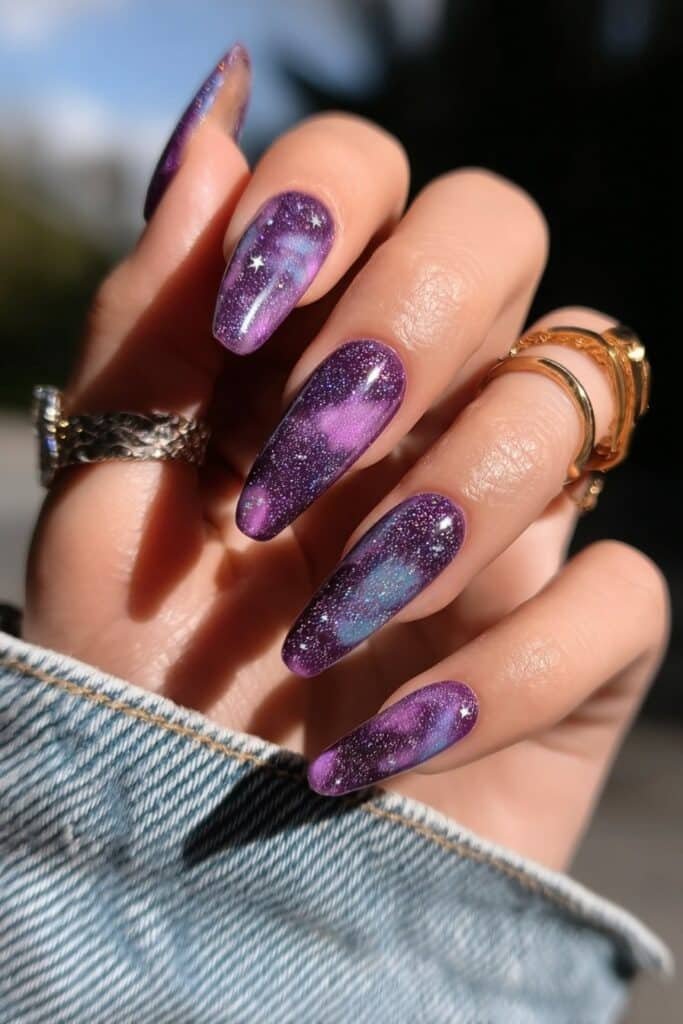 Coffin-shaped purple galaxy nails with star and shimmer details.