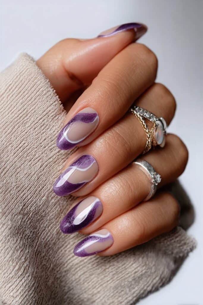 Almond nails featuring glossy purple polish with creative negative space cutouts.